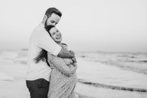 Black and white beach portraits capturing romantic moments by the ocean.
