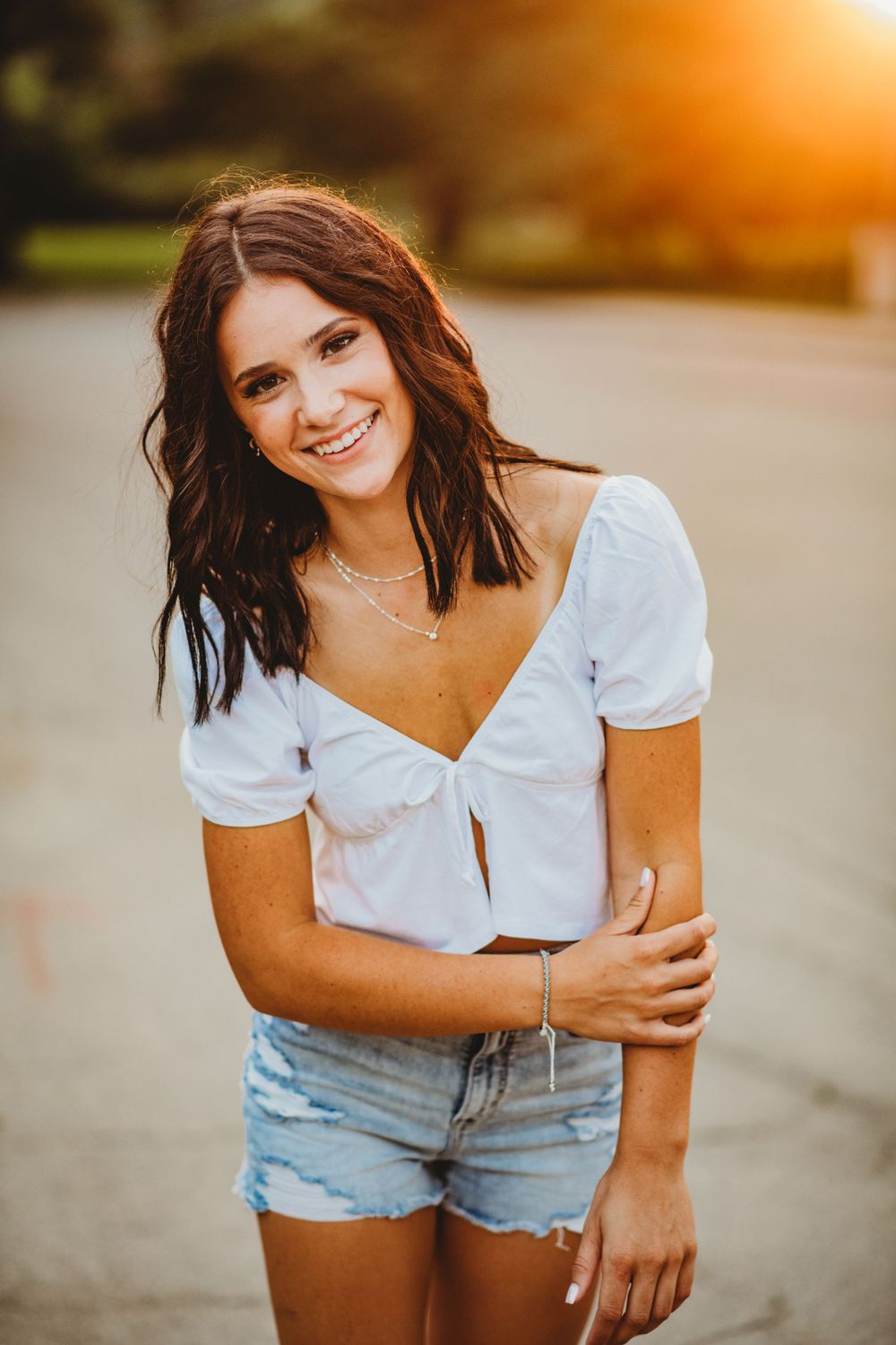 Summer sunset portrait series featuring white top and denim shorts in warm golden light.