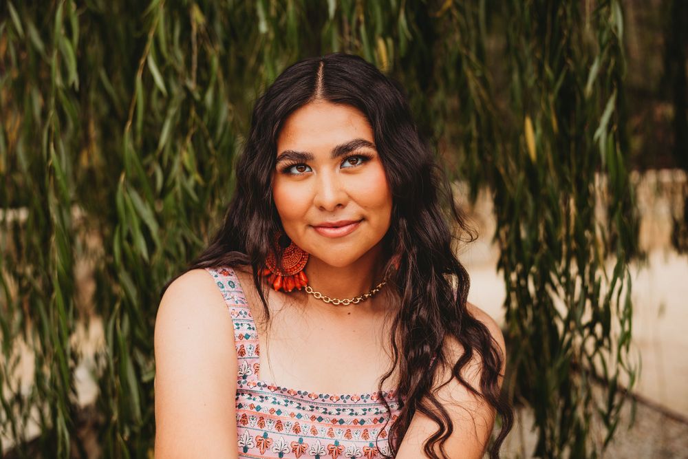 Portrait series featuring floral patterned top against willow tree background.