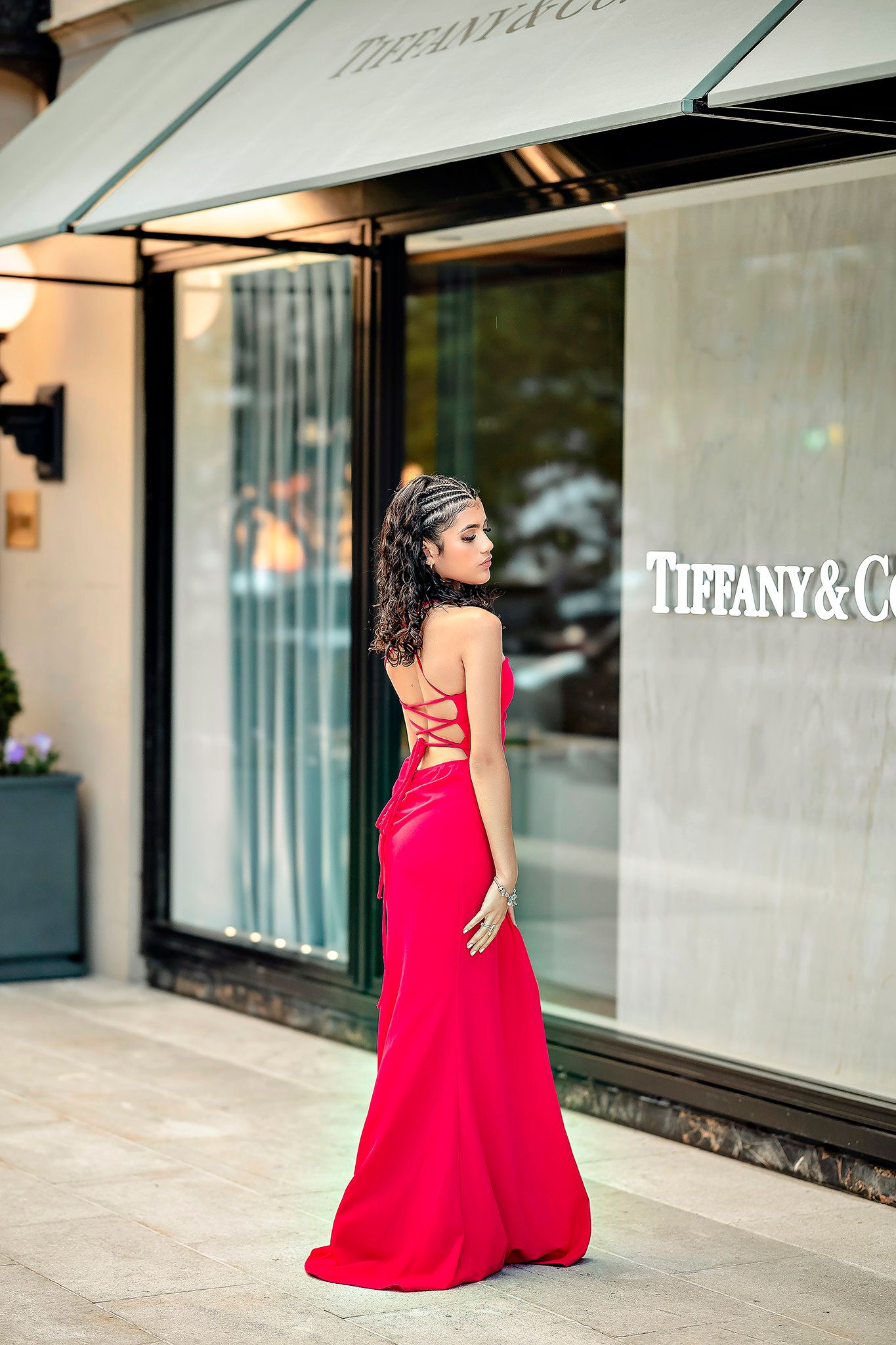 Fashion photo shoot in front of Tiffany & Co store featuring flowing red gown.