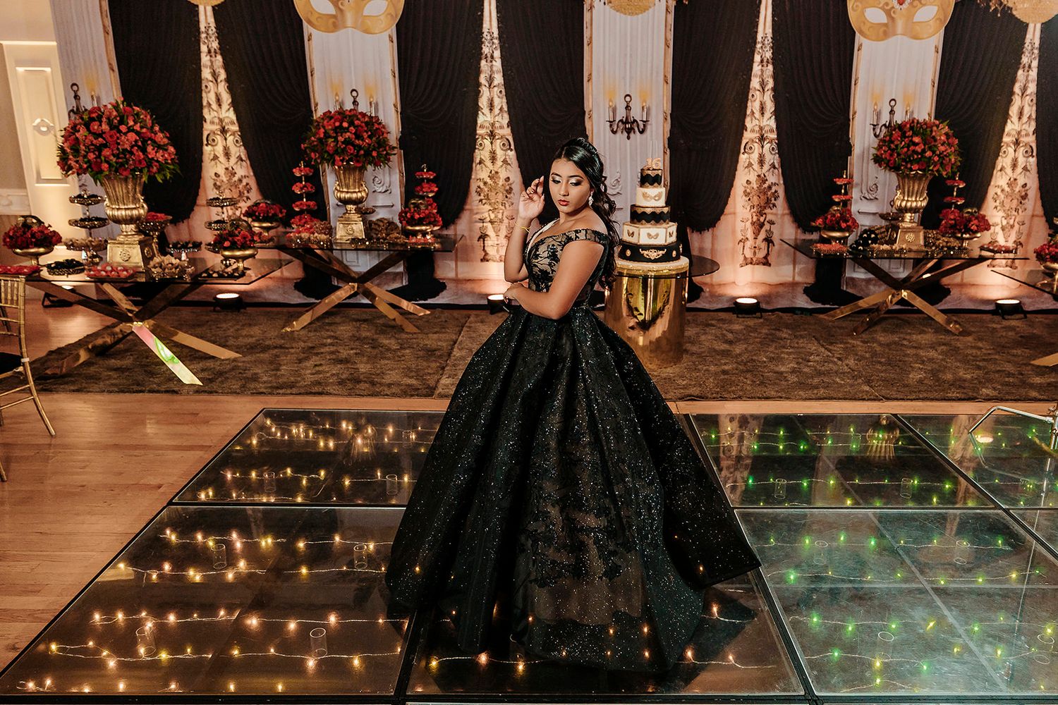 A wedding celebration featuring a grand hall with string lights, formal attire, and elegant table settings.