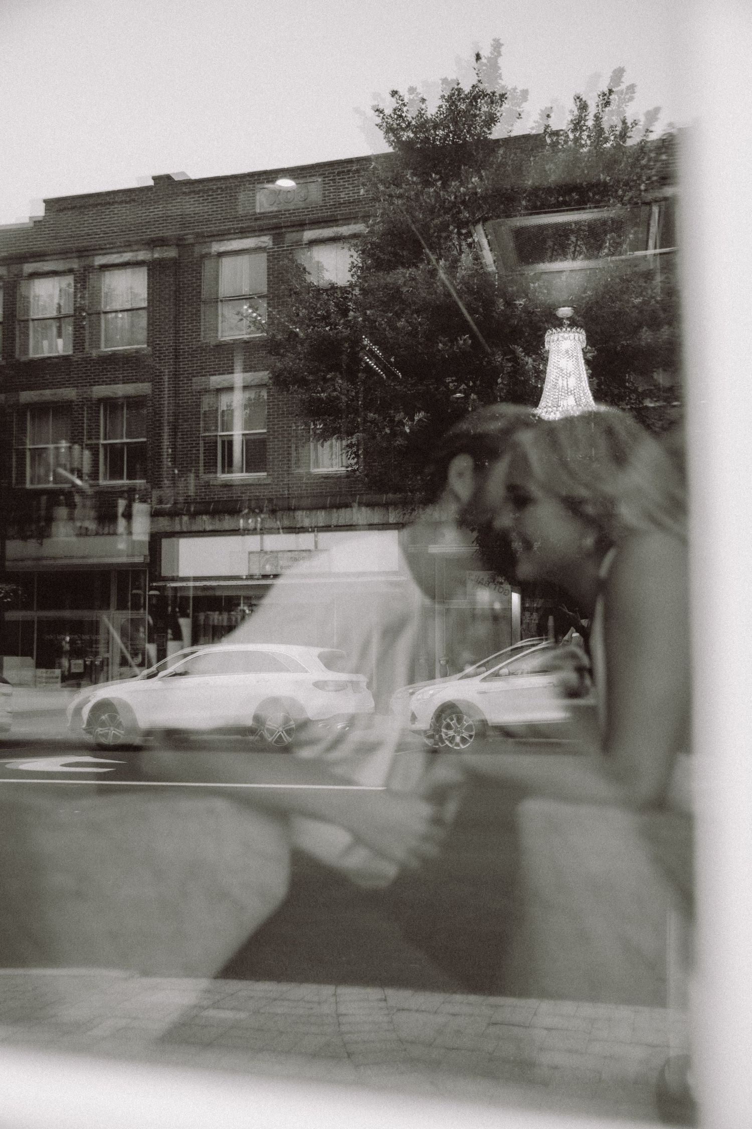 Double exposure photograph of urban street scene with buildings and trees.