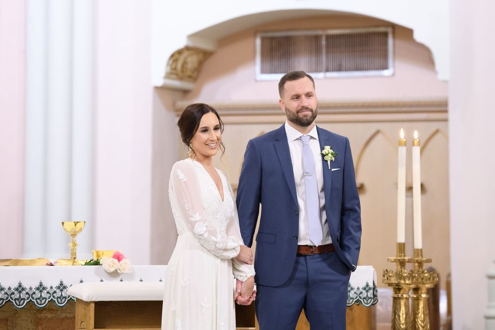 Couple stands at the altar during their wedding ceremony in a beautiful church.