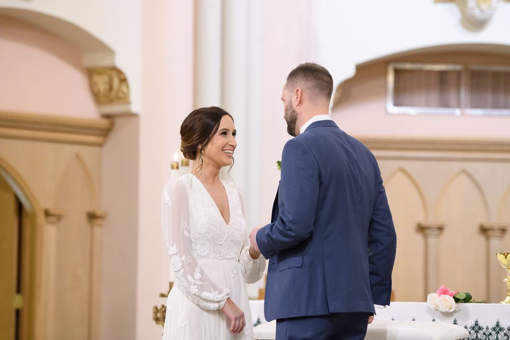 Couple shares a tender moment during their wedding ceremony in church.