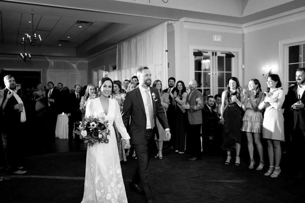 Black and white reception photos showing guests dancing and celebrating at an elegant indoor venue.