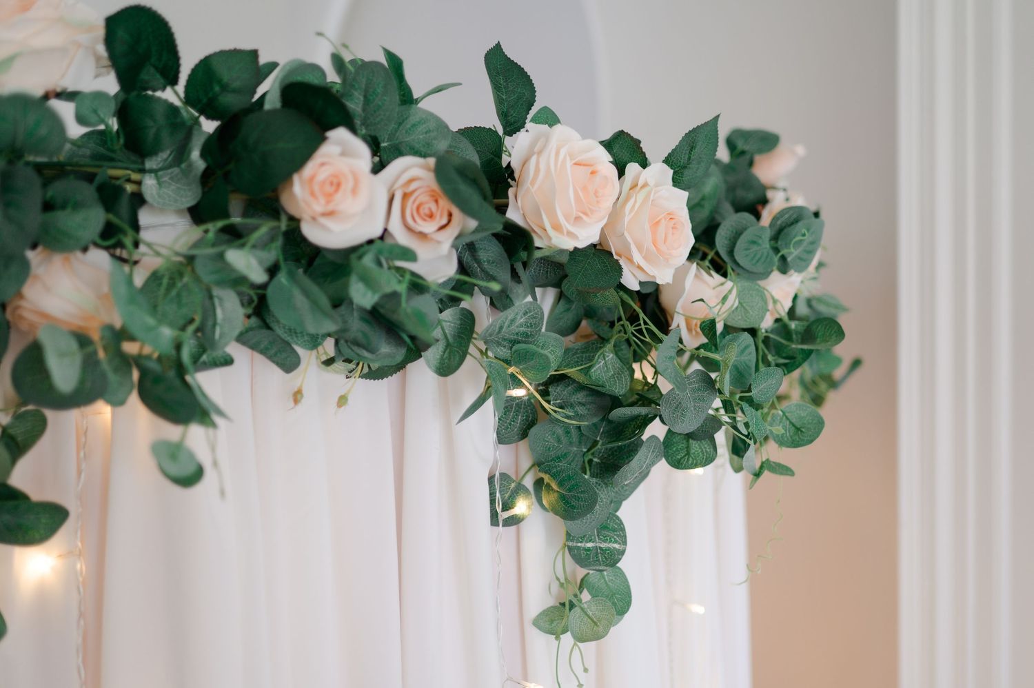 Curtained luxury photo booth hire with close up of flower garland and fairy lights