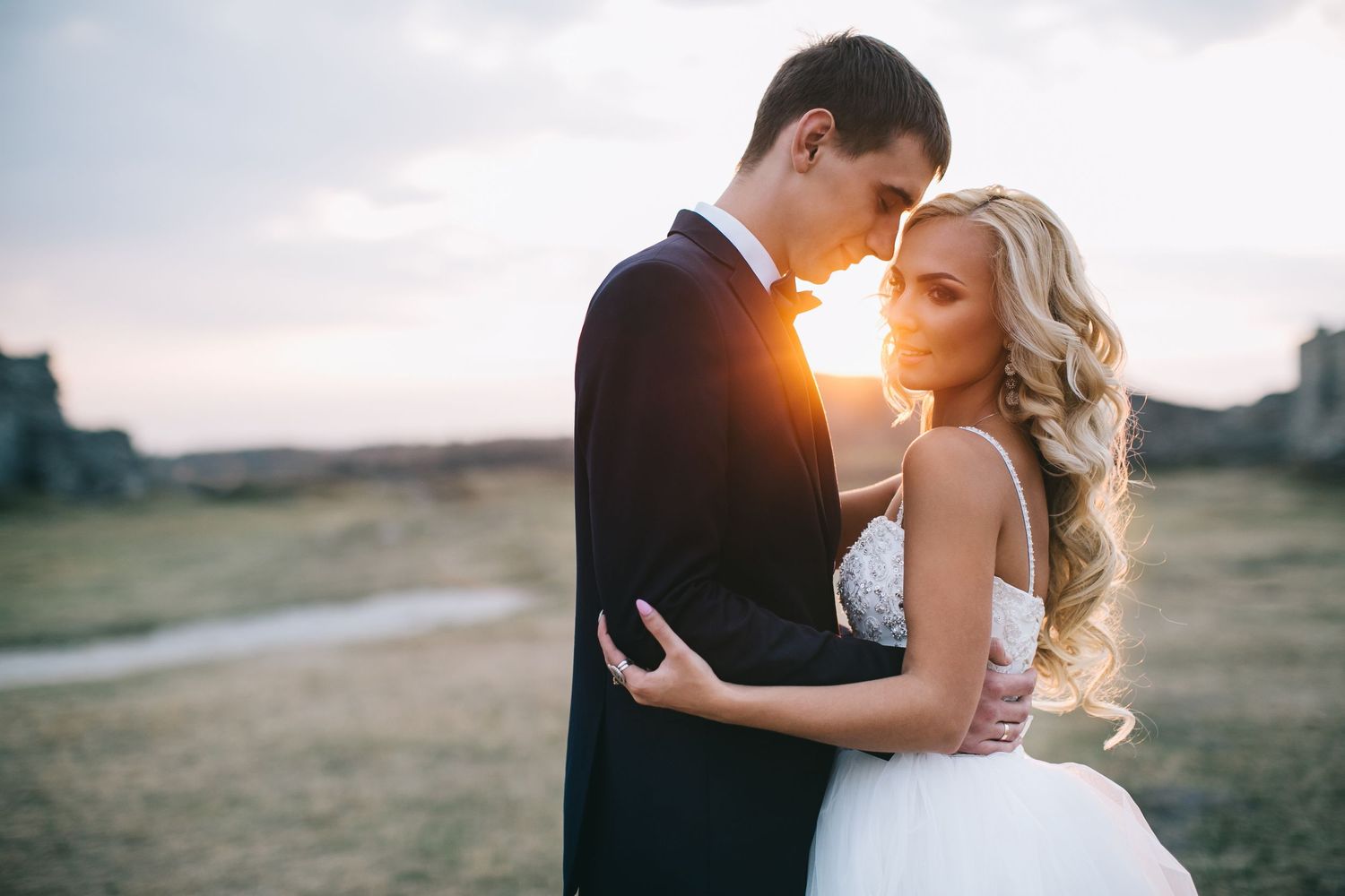 Romantic wedding portrait with sunset backlighting creating a warm glow.