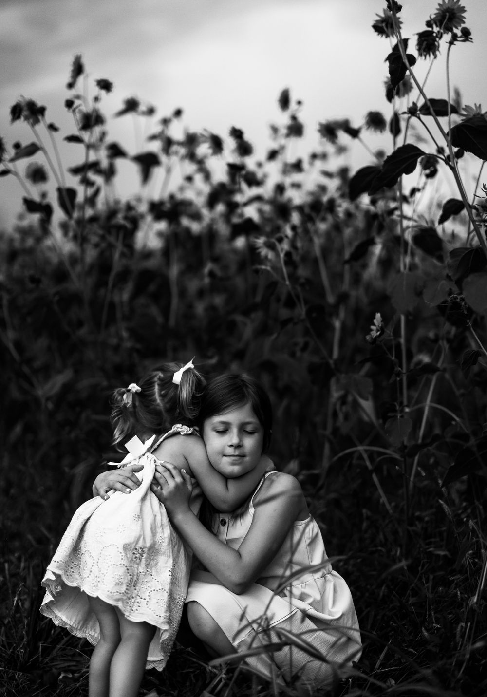 Black and white portrait of tender moment among wildflowers.