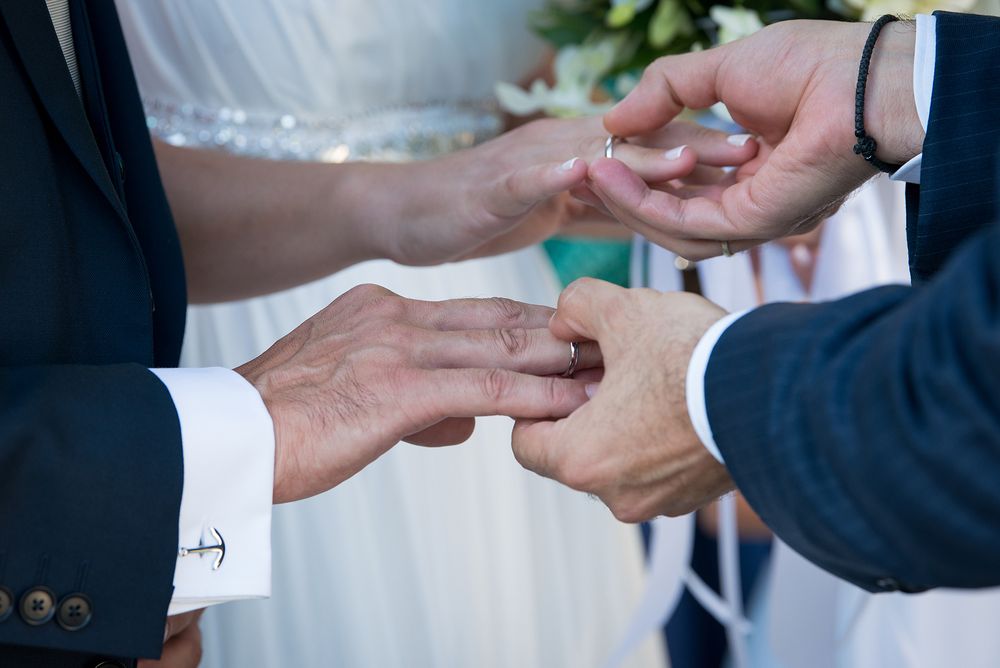 couple's and bestman's hands during the rings exchange