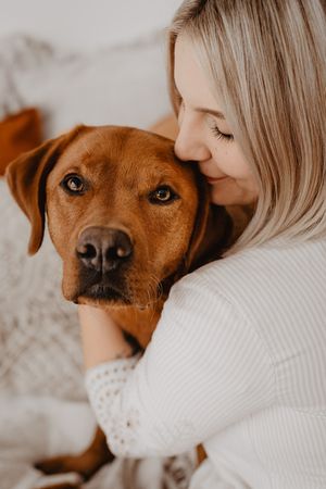 Frauchen küsst ihren Hund auf die Stirn