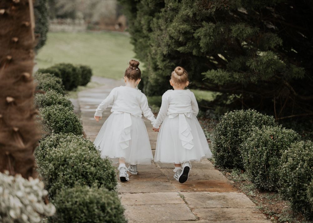 flower girls walking through the garden at a wedding at St Elizabeth's House in Plympton