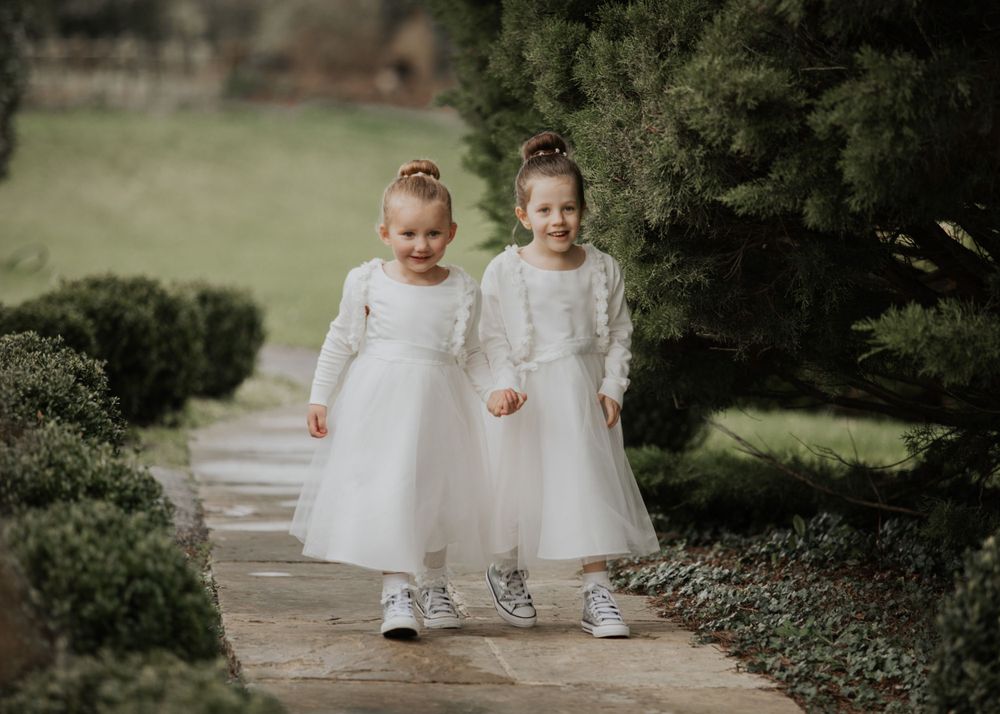 flower girls walking through the garden at a wedding at St Elizabeth's House in Plympton