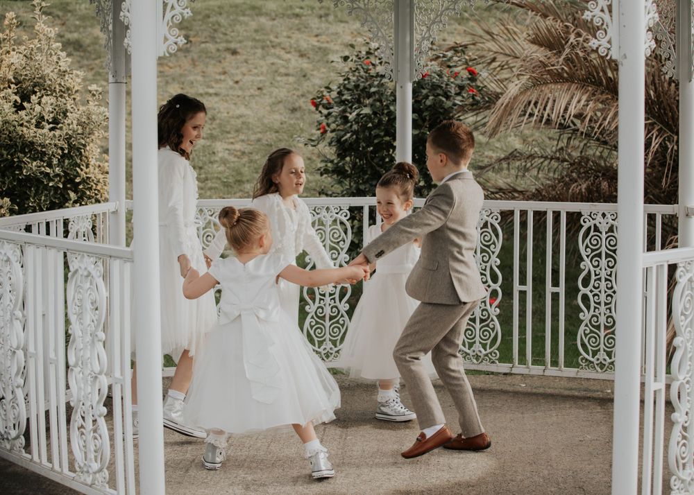 flower girls and Paige boys playing in the garden at a wedding at St Elizabeth's House in Plympton