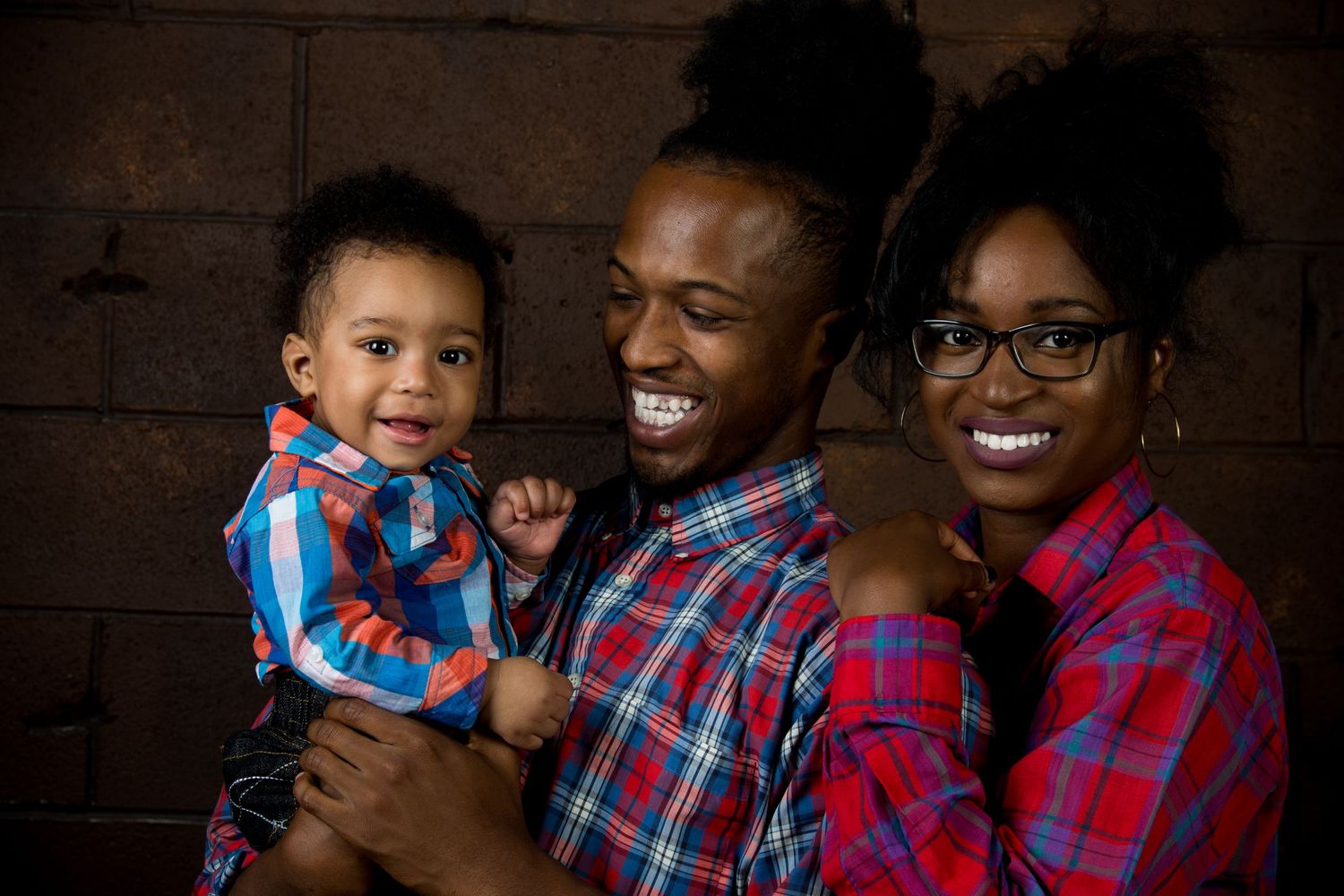 Family portrait session showing joyful expressions and matching plaid shirts.