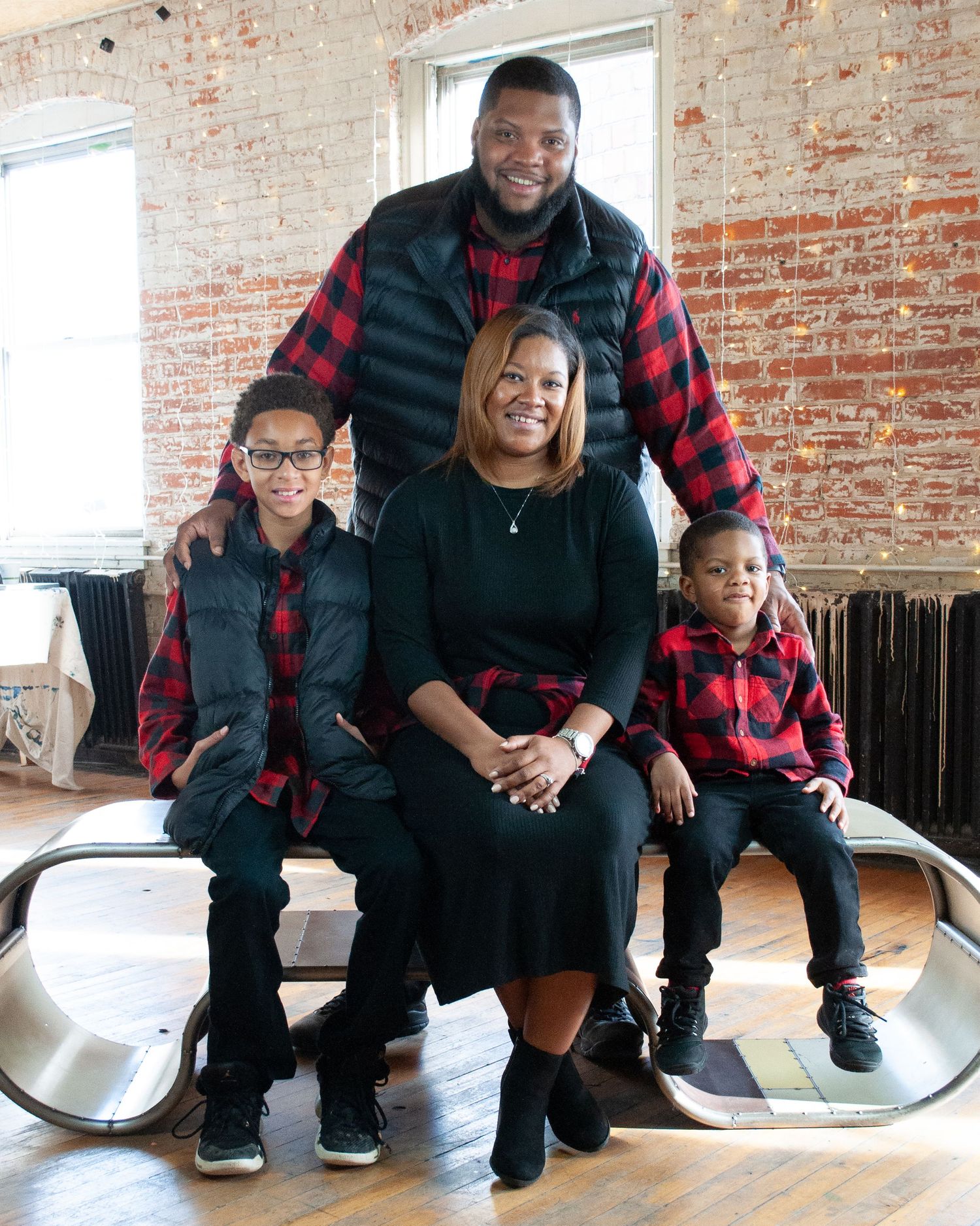 Family sitting together on modern furniture in rustic brick loft space.