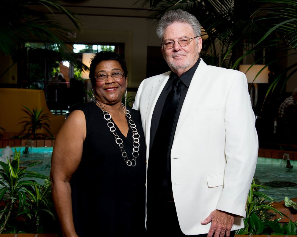 Formal event photos showing people in elegant black and white attire at an indoor venue.
