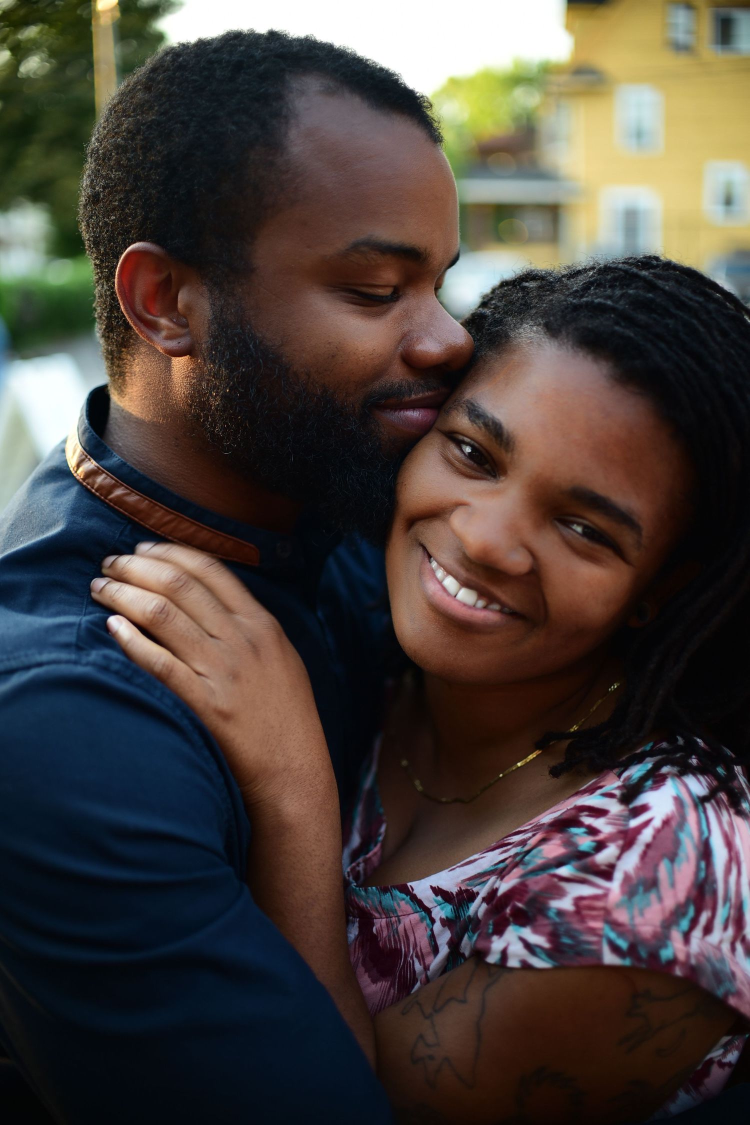Romantic couple sharing intimate moment during outdoor sunset photoshoot.