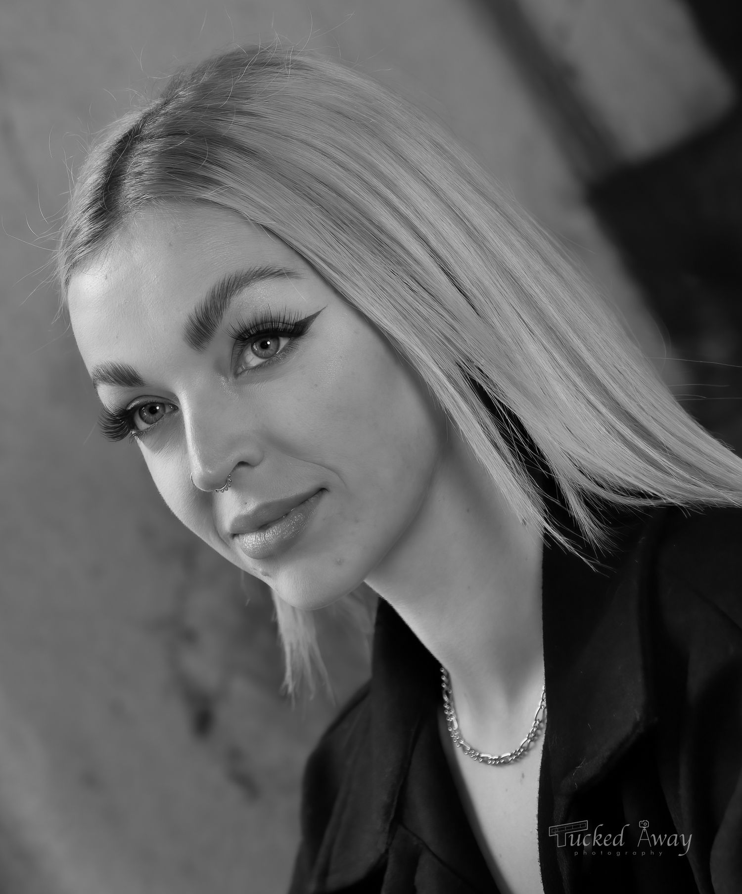 Black and white professional headshot with dramatic lighting and elegant styling.