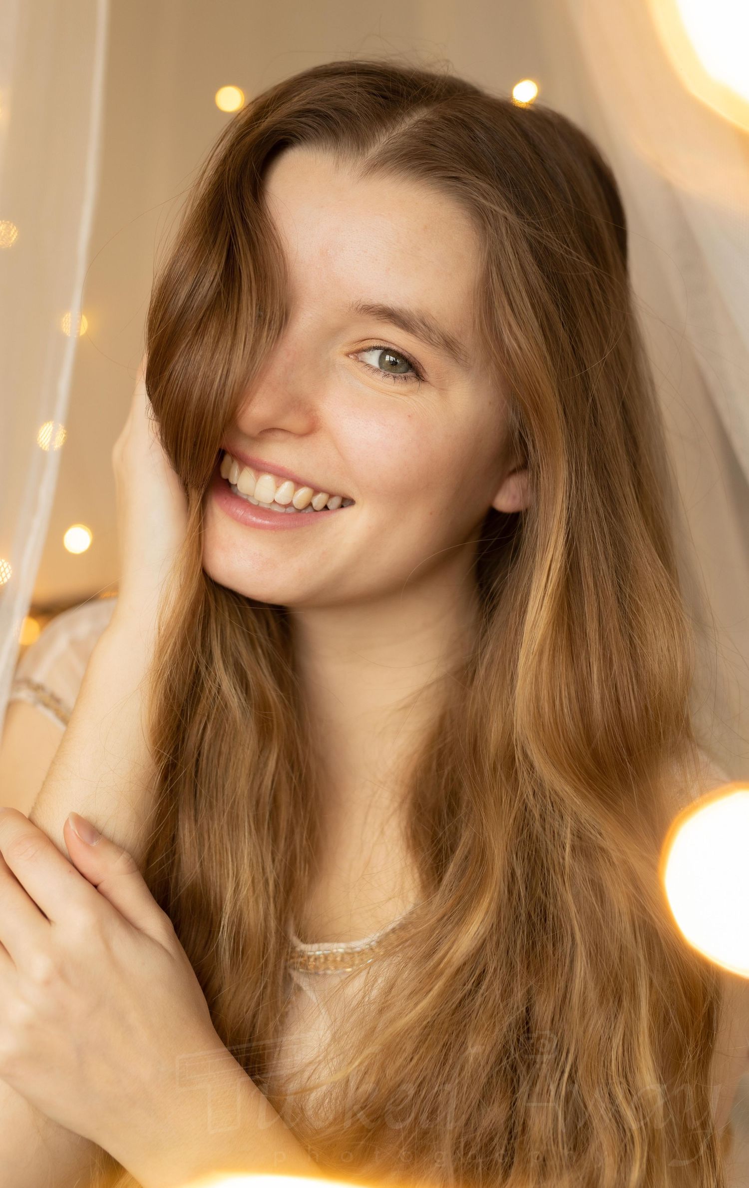 Warm portrait with soft lighting and string lights creating a cozy atmosphere.
