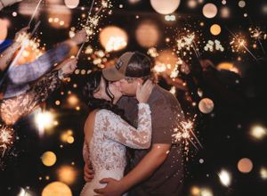 Dancing celebration with sparklers creating magical light bokeh effects at night.