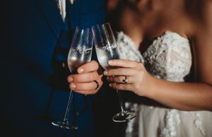 Close-up of champagne glasses being held during wedding celebration.