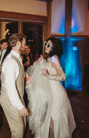 Couples dancing at wedding reception with blue and green ambient lighting.