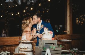 Wedding reception setup with romantic lighting and rustic decor at dusk.