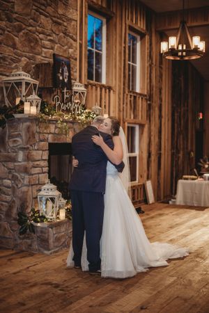 First dance in a rustic stone and wood venue with romantic lighting and decor.