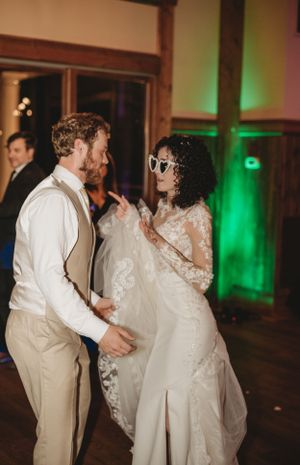 Wedding reception dance party with green uplighting and elegant decor.
