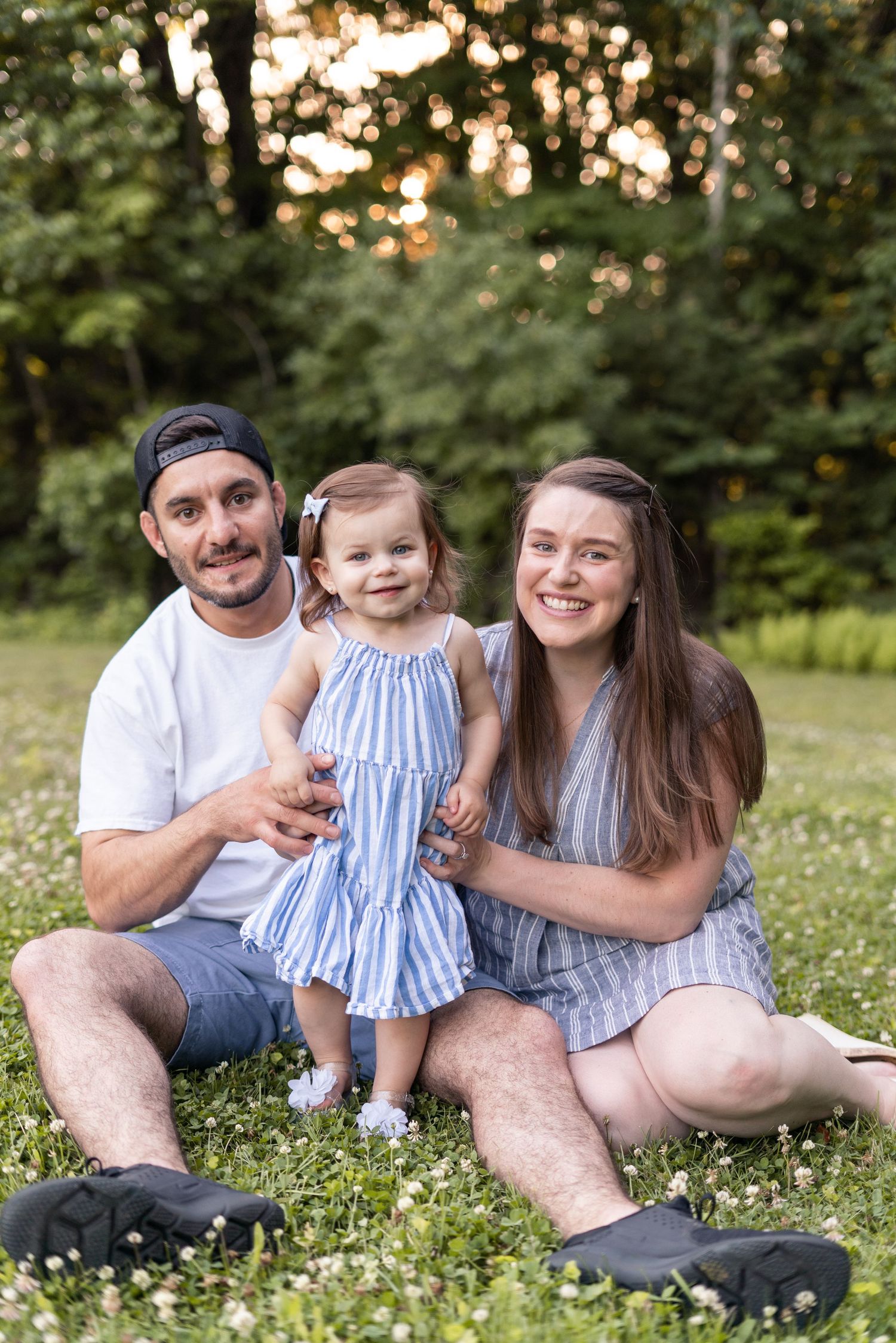 Family sitting in wildflower meadow at sunset.