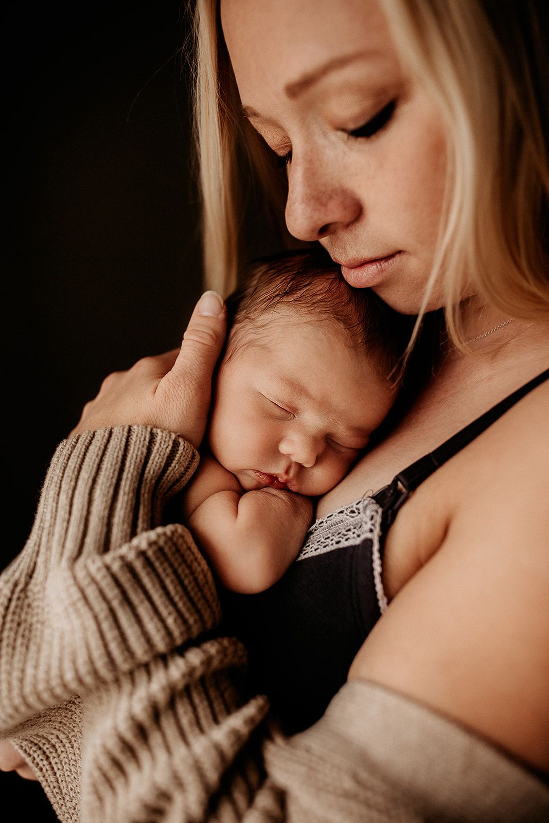 A baby rests on her mother's chest while sleeping.