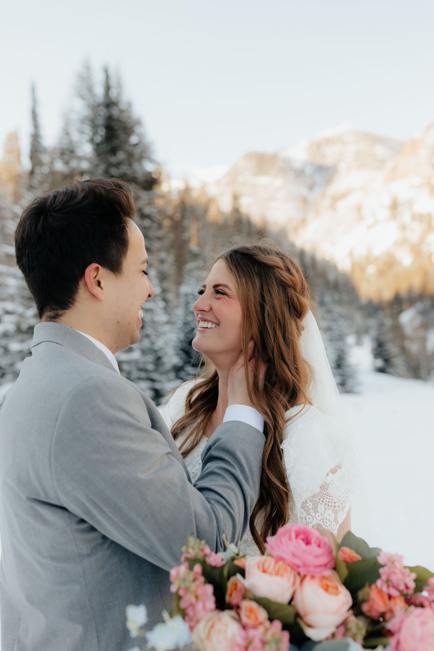 Bride and Groom laughing with each other in snowy mountains