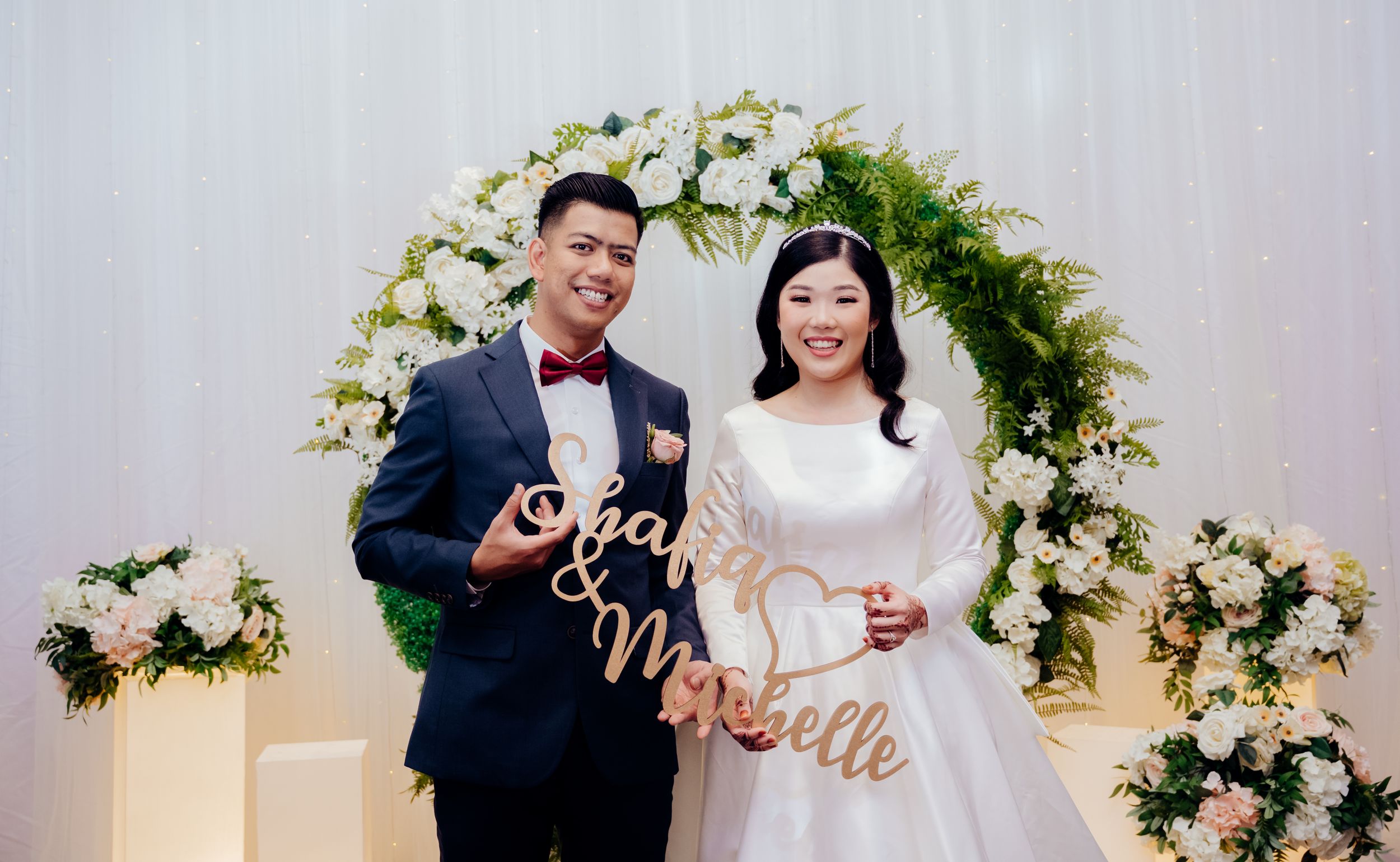 Wedding day couple smiling into camera with their names printed