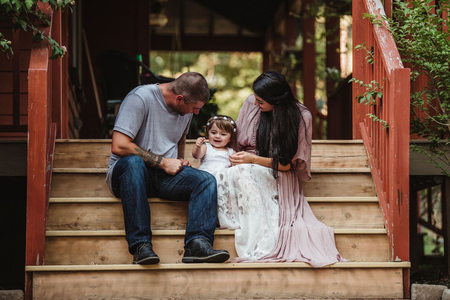 A tender moment shared on wooden porch steps during a family photo session.