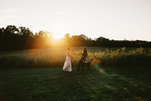 Sunset wedding photoshoot in a serene field with golden hour lighting and natural scenery.