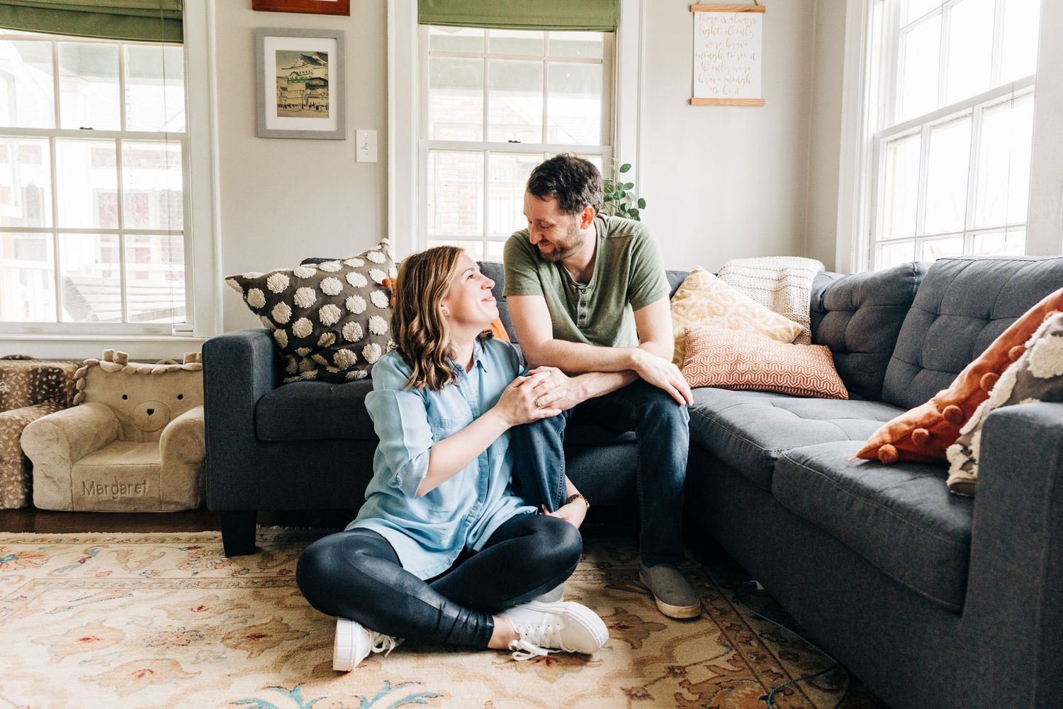 A husband and wife smile at each other in their Charlotte, NC living room