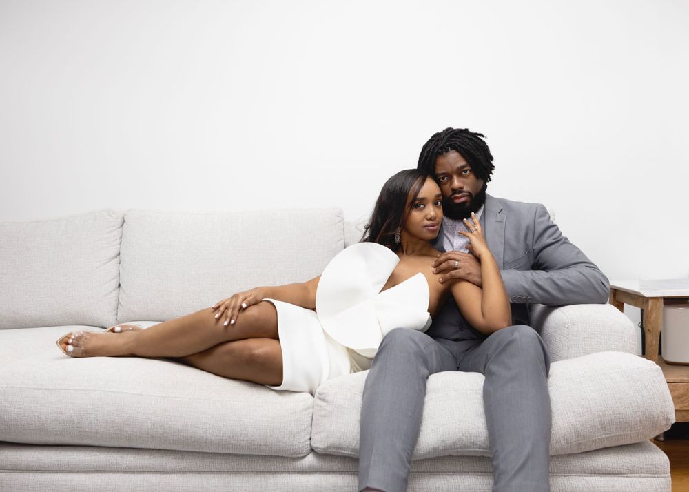 Couple relaxing together on white couch in intimate moment.