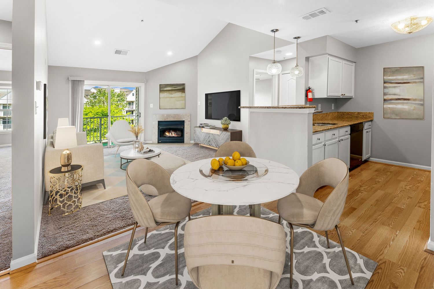 Open concept living space with white kitchen cabinets, hardwood floors, and modern dining area.