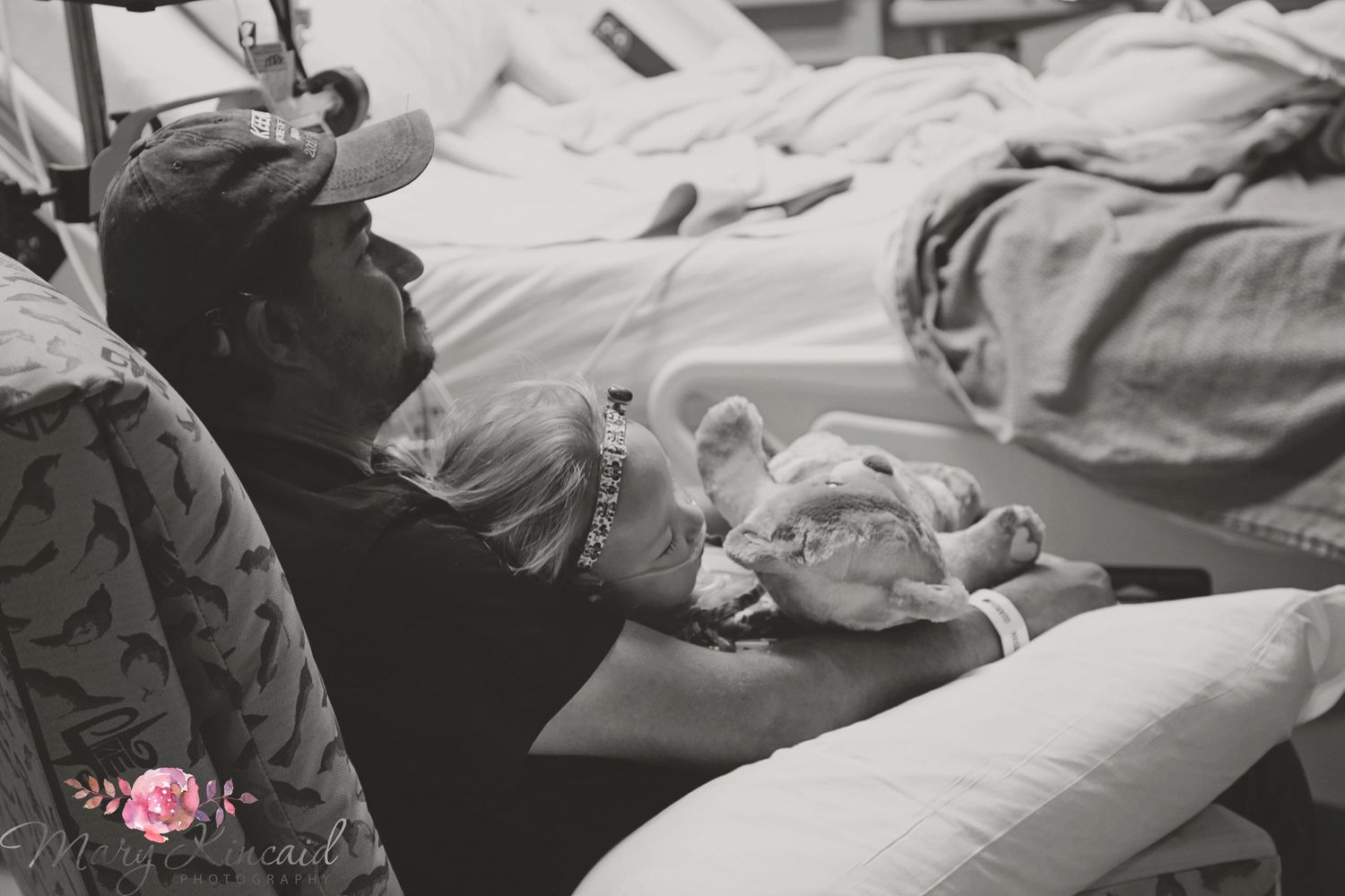 Little girl and her daddy snuggling in the hospital after she had open heart surgery.