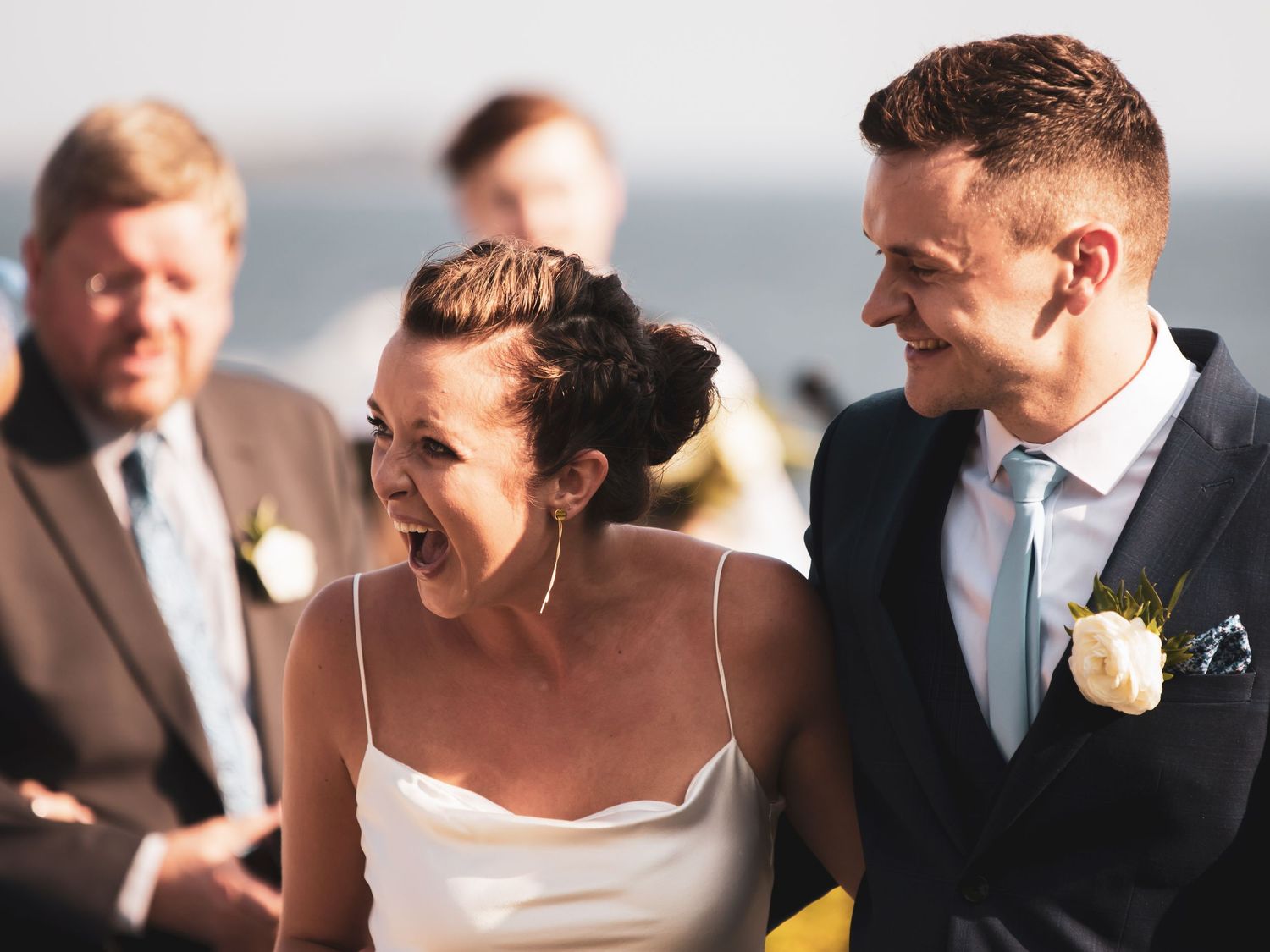 close up of bride and groom smiling at guests