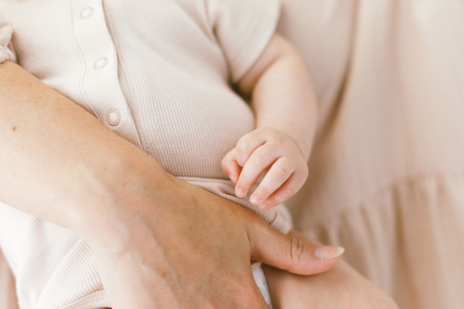 Detail shots focusing on tiny baby hands and soft fabric textures.