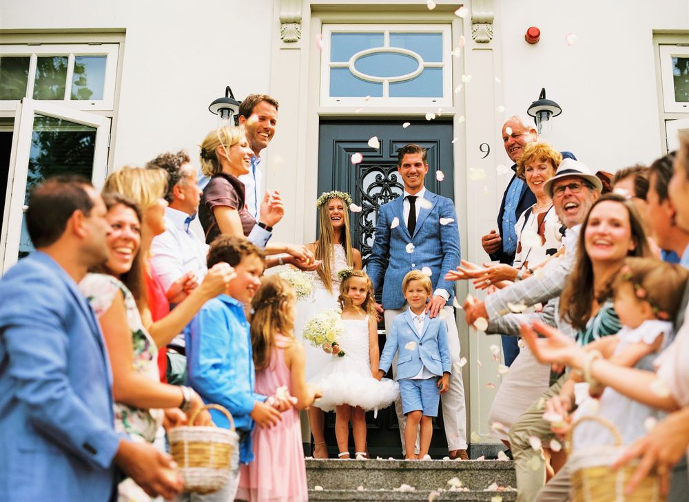 A celebratory gathering on stone steps with a crowd throwing confetti.