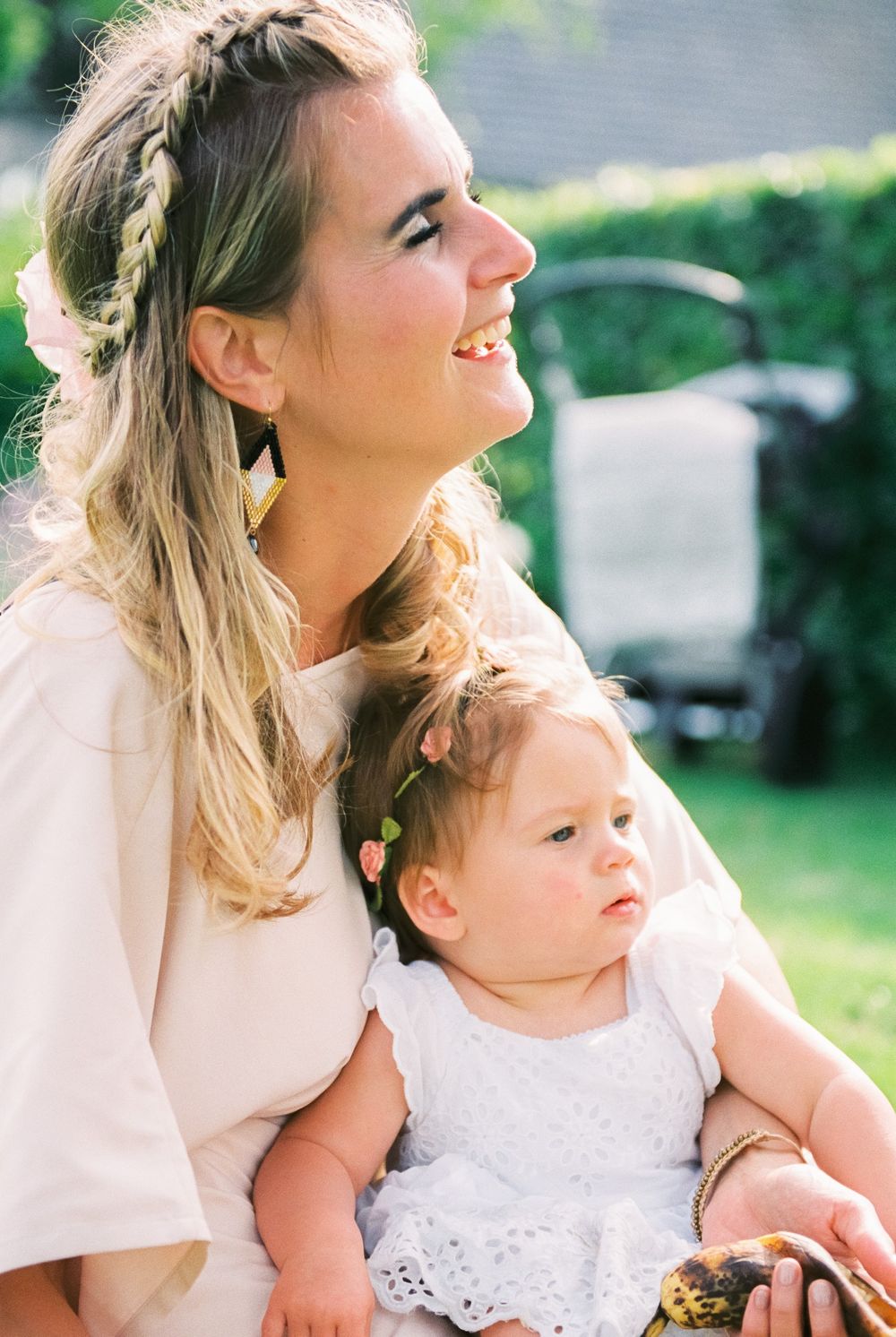A tender moment captured between parent and baby outdoors in soft natural light.