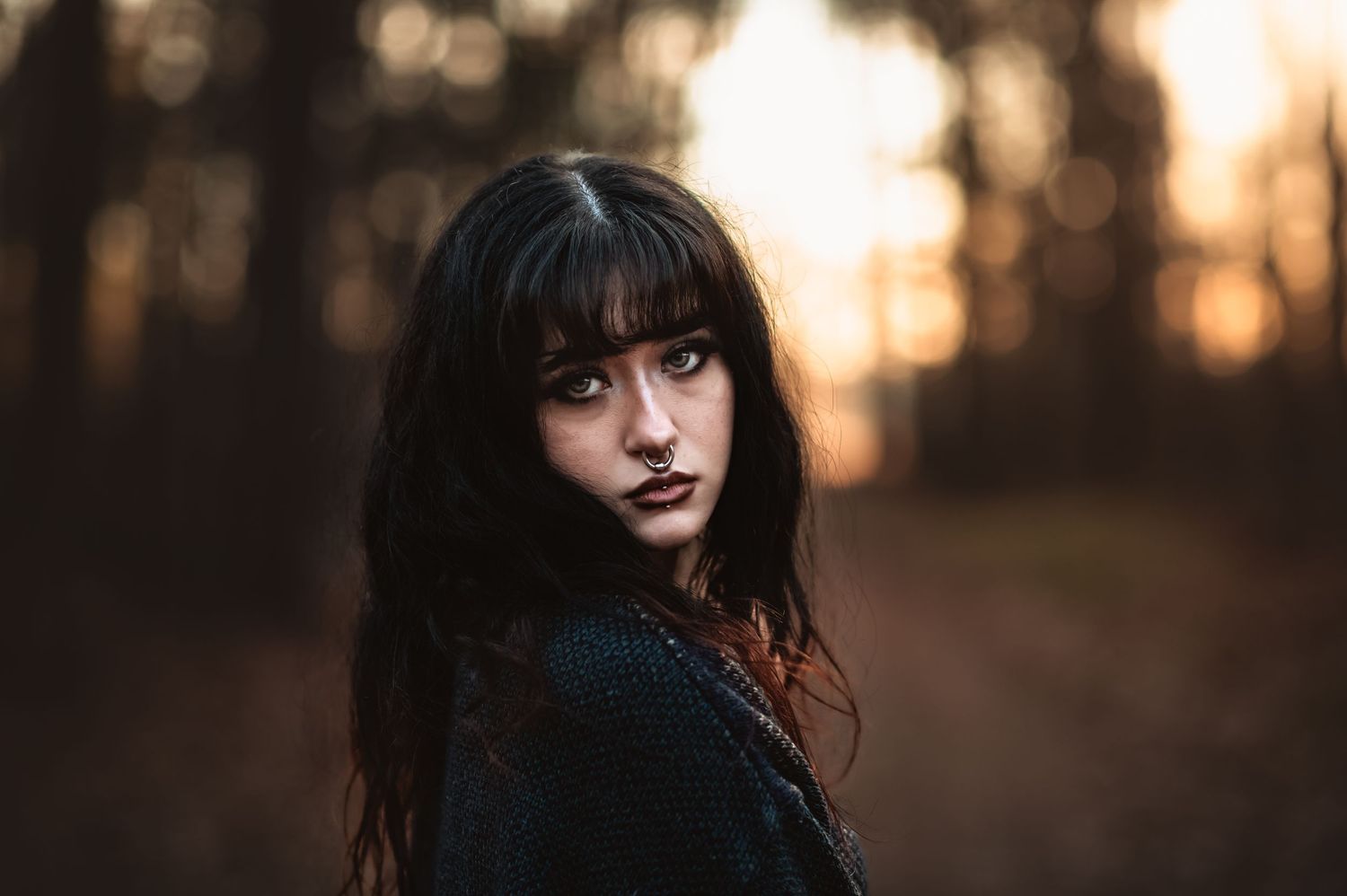 A high school senior in the woods with dark hair at sunset for senior photo session at Chickamauga Battlefield