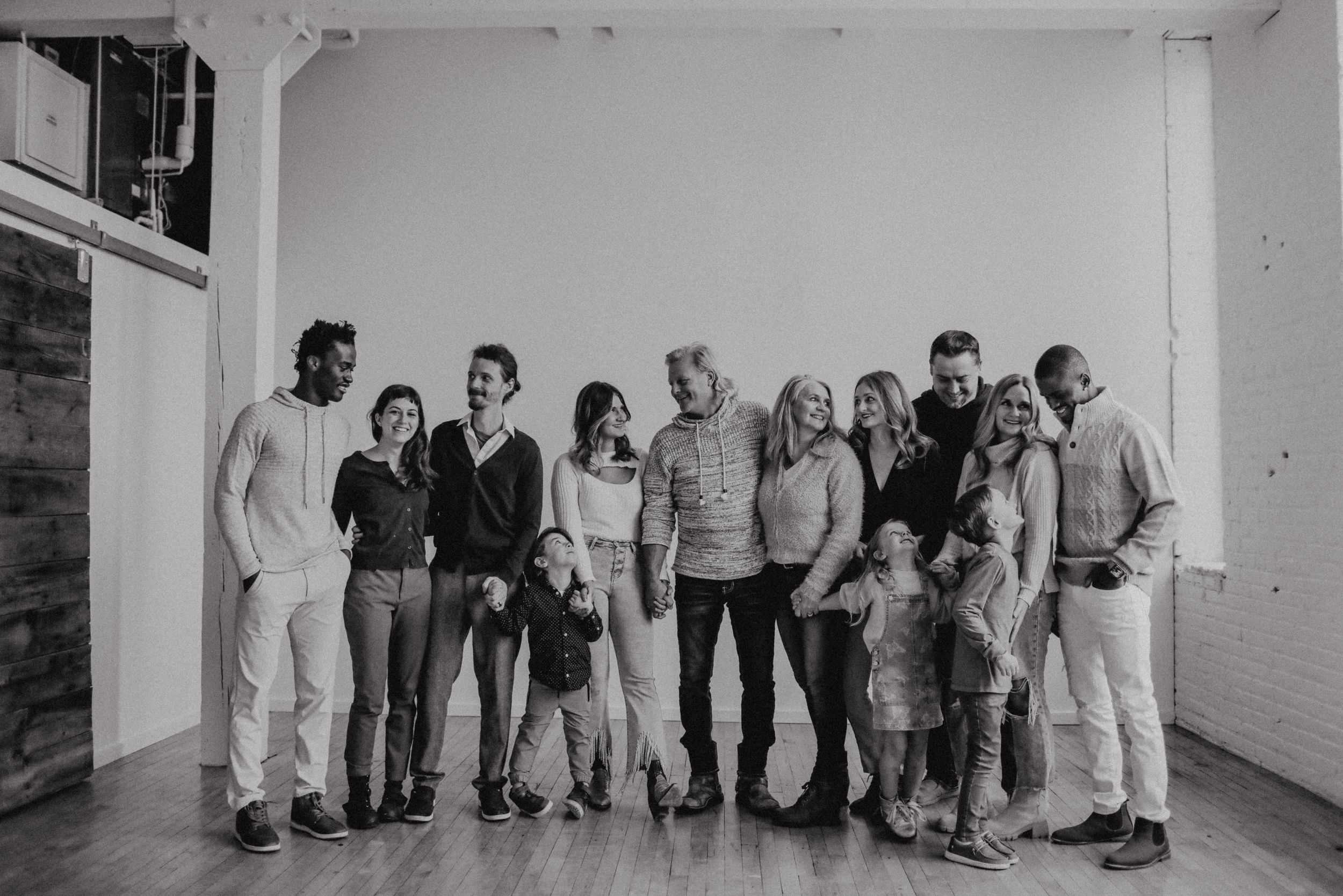 A panoramic black and white group photo showing multiple people lined up along a white wall.