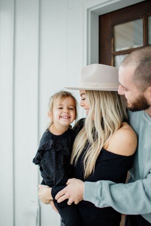 Family sharing joyful moments together against a white wall.