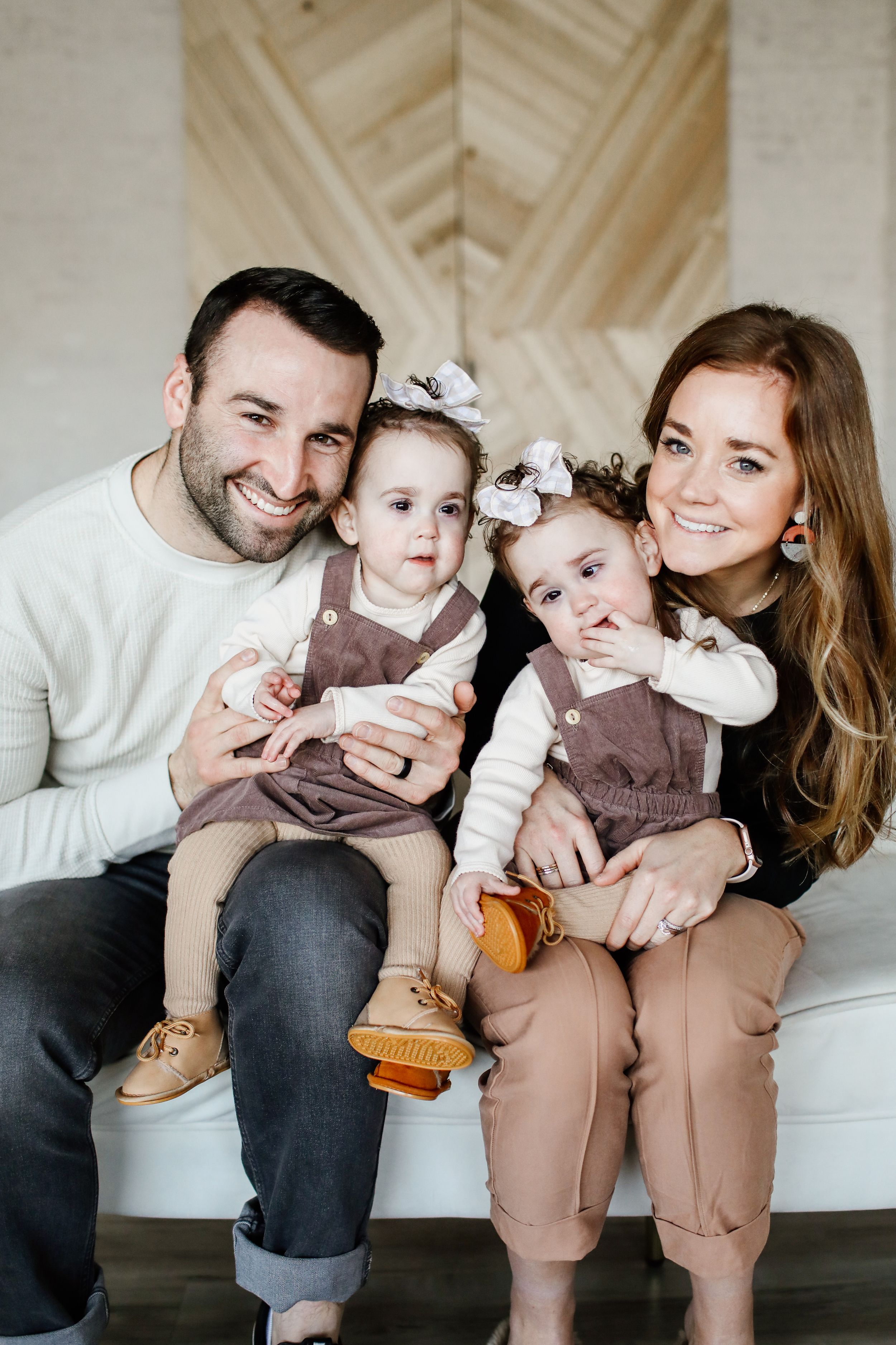 Family portrait series showing playful moments on a light colored couch.