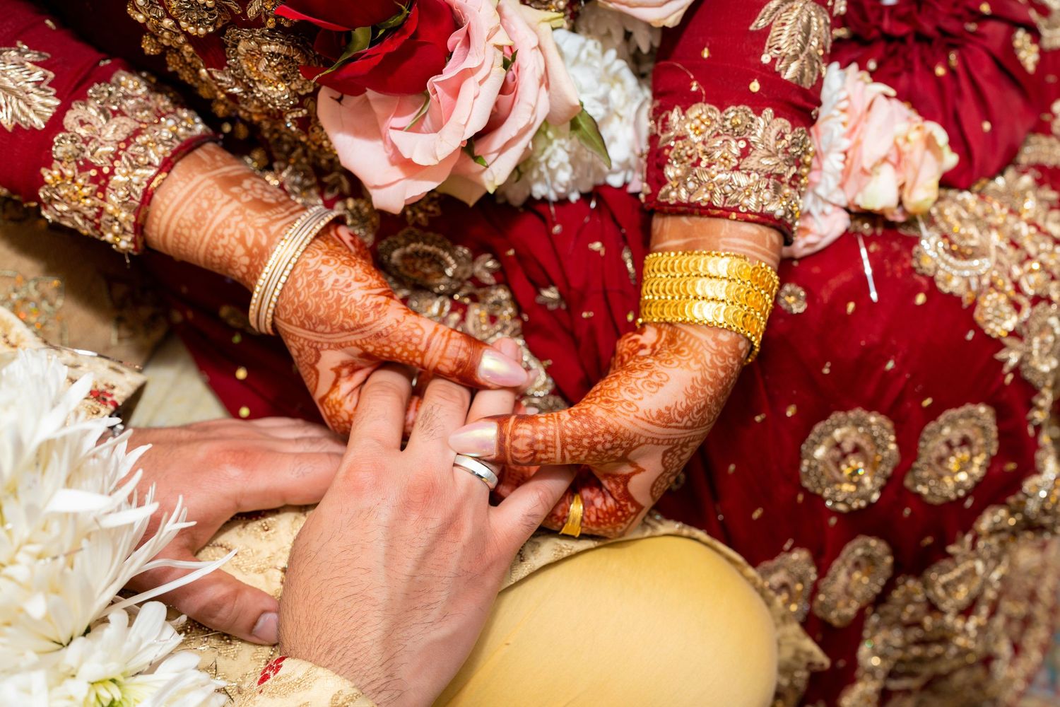 Traditional mehndi ceremony showing hands decorated with intricate henna designs during an Indian wedding celebration.