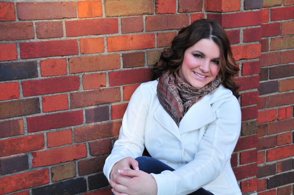 high school senior girl against brick wall