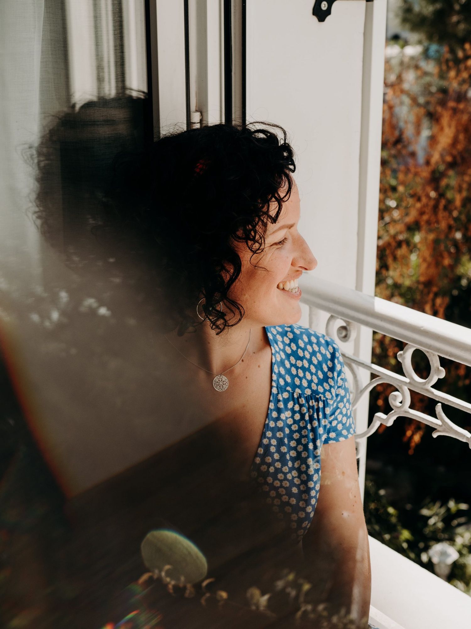 Sunlit balcony scene with romantic lighting and wrought iron details.